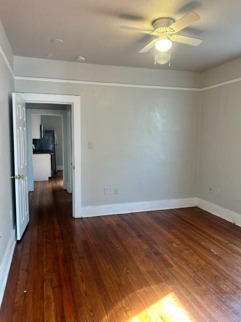 empty room with dark hardwood / wood-style floors and ceiling fan