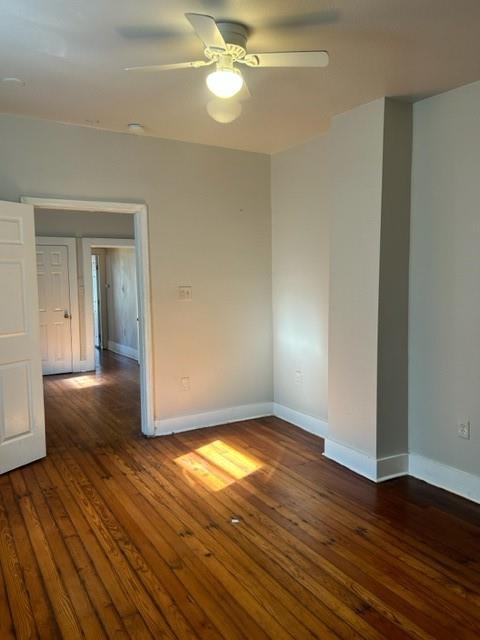 spare room with dark hardwood / wood-style floors and ceiling fan