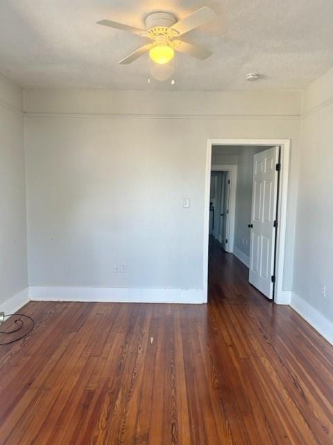 unfurnished room with ceiling fan and dark hardwood / wood-style flooring