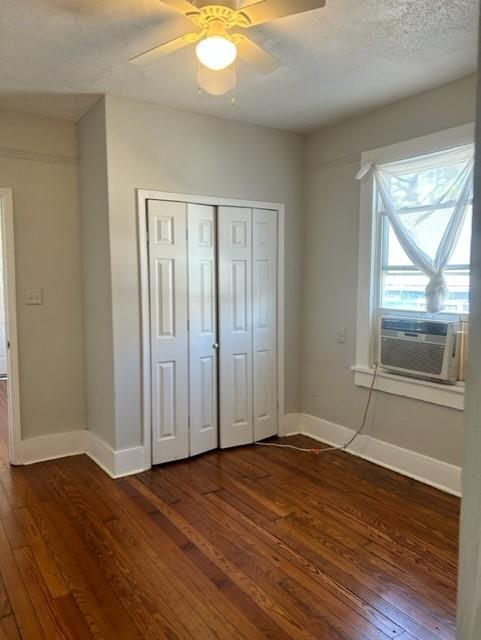 unfurnished bedroom with a closet, ceiling fan, and dark hardwood / wood-style flooring