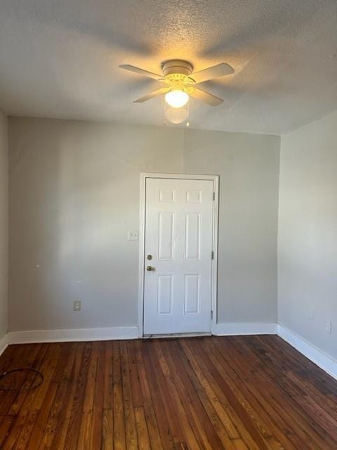 spare room with a textured ceiling, dark hardwood / wood-style flooring, and ceiling fan