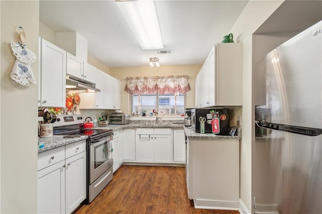 kitchen featuring light stone countertops, appliances with stainless steel finishes, dark hardwood / wood-style flooring, sink, and white cabinetry