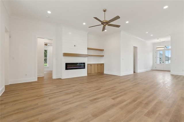 unfurnished living room with ceiling fan, plenty of natural light, and ornamental molding