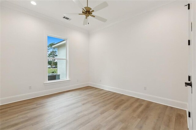 empty room featuring ceiling fan, ornamental molding, and light wood-type flooring