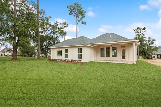 rear view of property featuring ceiling fan, a patio area, and a yard