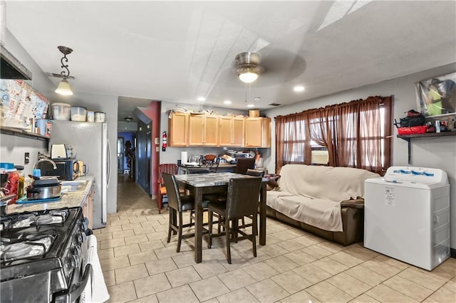 dining room with light tile patterned floors, washer / clothes dryer, and ceiling fan