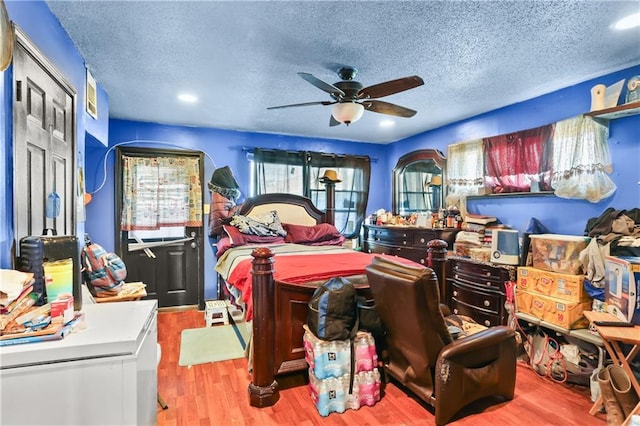 bedroom featuring a textured ceiling, light hardwood / wood-style floors, and ceiling fan