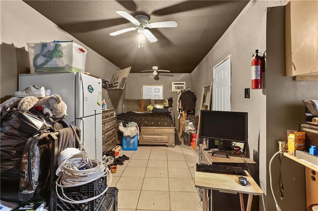 kitchen with ceiling fan, light tile patterned floors, a textured ceiling, white fridge, and a wall unit AC