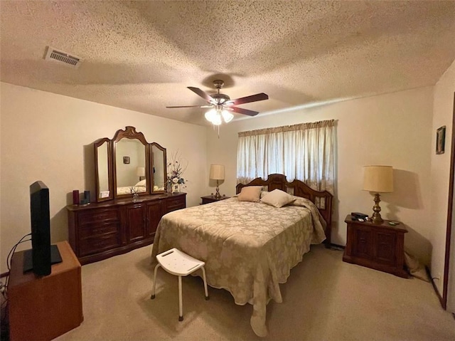 carpeted bedroom featuring a textured ceiling and ceiling fan