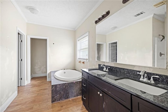 bathroom featuring hardwood / wood-style floors, vanity, a relaxing tiled tub, and ornamental molding