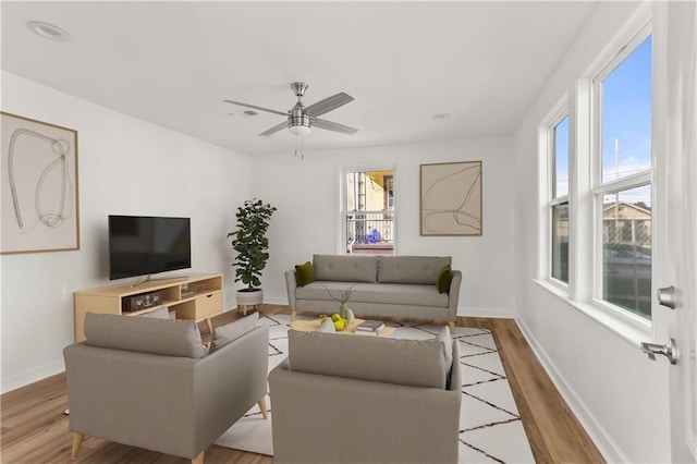 living room with ceiling fan, a healthy amount of sunlight, and light hardwood / wood-style flooring