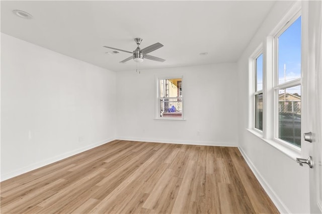 spare room featuring a wealth of natural light, ceiling fan, and light hardwood / wood-style floors