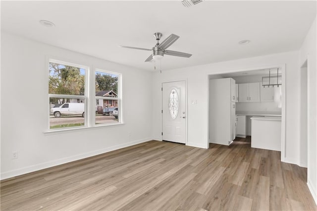 unfurnished living room with ceiling fan and light wood-type flooring