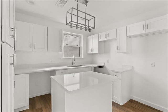 kitchen featuring white cabinetry, a center island, sink, dark hardwood / wood-style floors, and decorative light fixtures