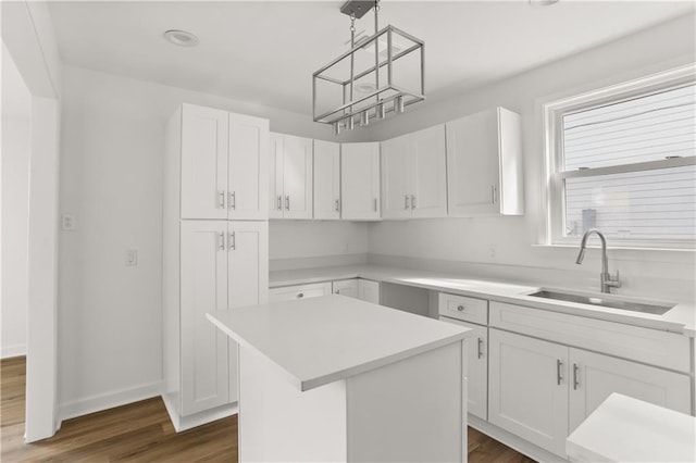 kitchen with sink, a center island, dark hardwood / wood-style floors, white cabinetry, and hanging light fixtures