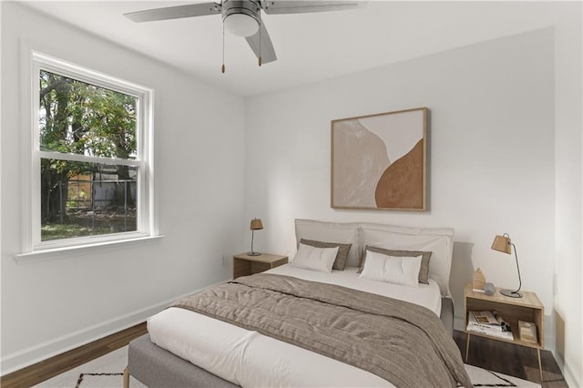 bedroom with ceiling fan and dark hardwood / wood-style flooring