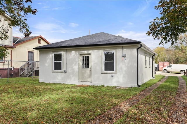 rear view of house featuring a lawn