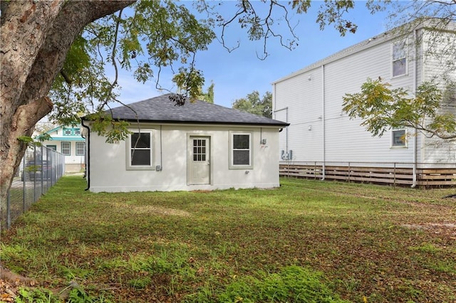 rear view of house featuring a yard