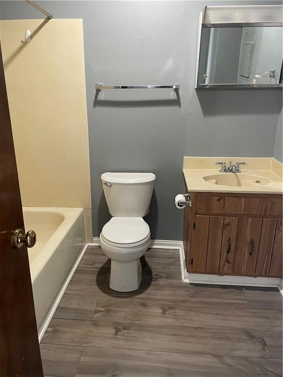 bathroom featuring wood-type flooring, vanity, and toilet