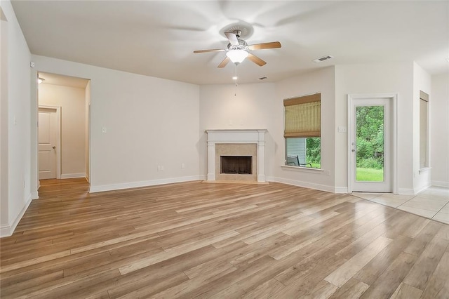 unfurnished living room featuring ceiling fan, light hardwood / wood-style floors, and a high end fireplace