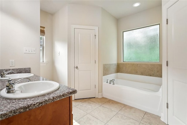 bathroom with tile patterned floors, vanity, and a bath