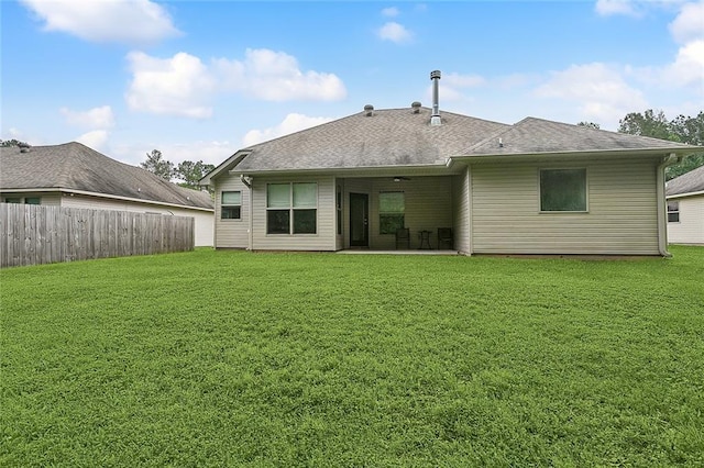 rear view of property featuring a patio and a lawn