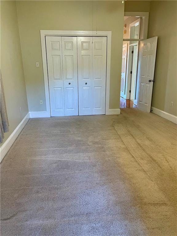 unfurnished bedroom with light carpet and a closet