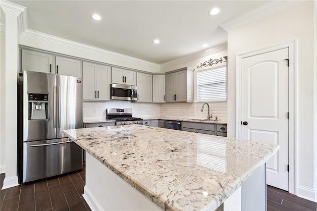 kitchen featuring a center island, sink, light stone counters, dark hardwood / wood-style flooring, and appliances with stainless steel finishes