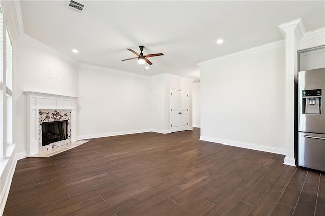 unfurnished living room featuring crown molding, ceiling fan, dark hardwood / wood-style flooring, and a fireplace