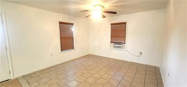 spare room with ceiling fan and light tile patterned floors