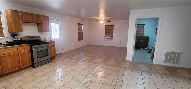 kitchen featuring gas range, light tile patterned floors, and ceiling fan