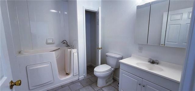 bathroom with tile patterned flooring, vanity, toilet, and a shower