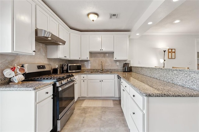 kitchen featuring kitchen peninsula, appliances with stainless steel finishes, light stone countertops, sink, and white cabinets