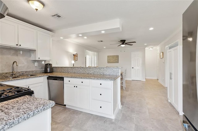 kitchen with decorative backsplash, white cabinetry, ceiling fan, and stainless steel dishwasher