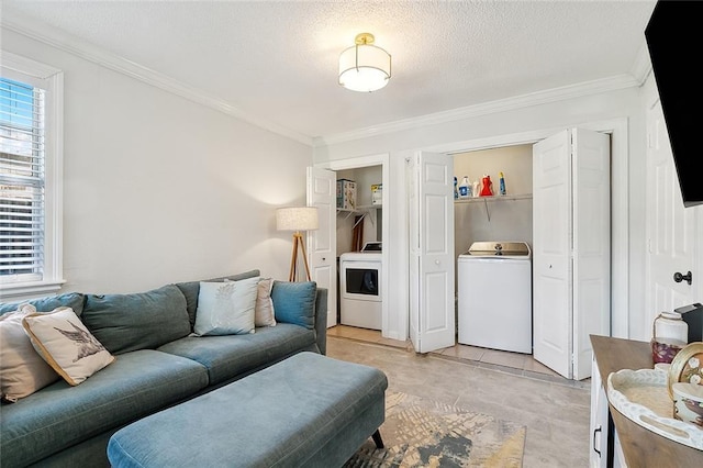 living room featuring a textured ceiling, washer / clothes dryer, ornamental molding, and light tile patterned flooring