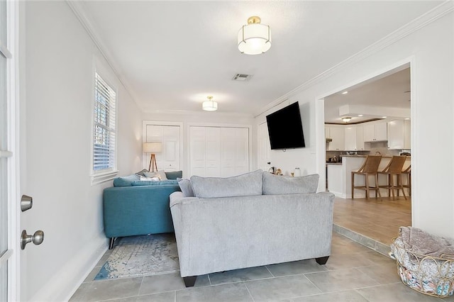 living room featuring crown molding and light tile patterned floors