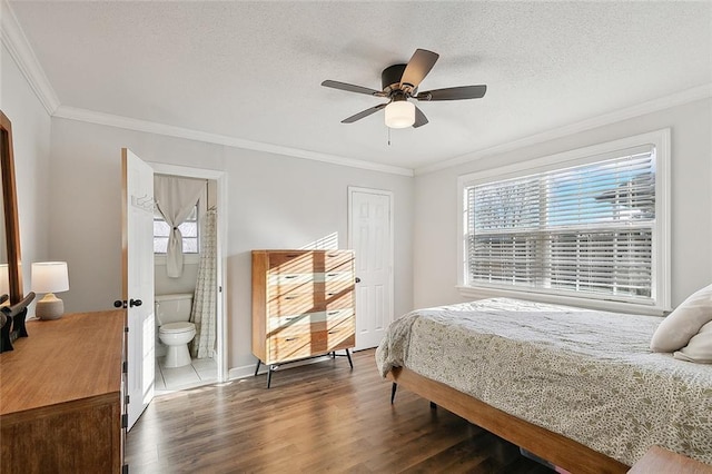 bedroom featuring ensuite bath, ceiling fan, ornamental molding, a textured ceiling, and dark hardwood / wood-style flooring