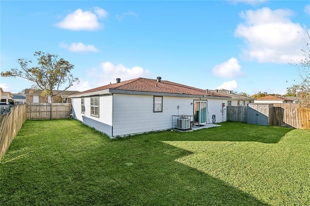 rear view of property featuring a yard and central AC unit