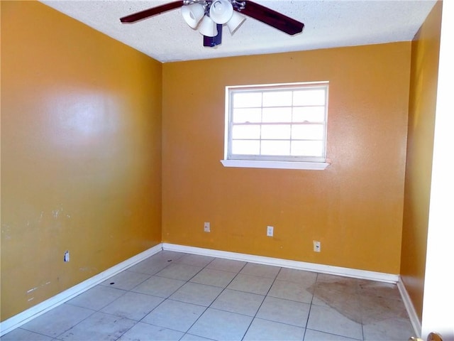 tiled empty room with ceiling fan and a textured ceiling