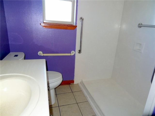 bathroom with tile patterned flooring, toilet, and sink