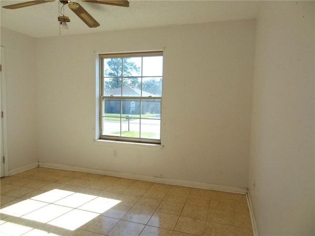 tiled spare room with ceiling fan