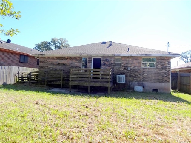 rear view of property featuring a yard and a wooden deck