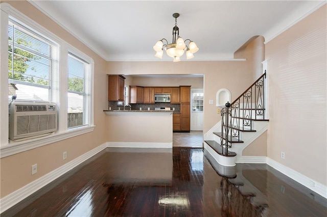 kitchen featuring a chandelier, ornamental molding, dark wood-type flooring, and tasteful backsplash