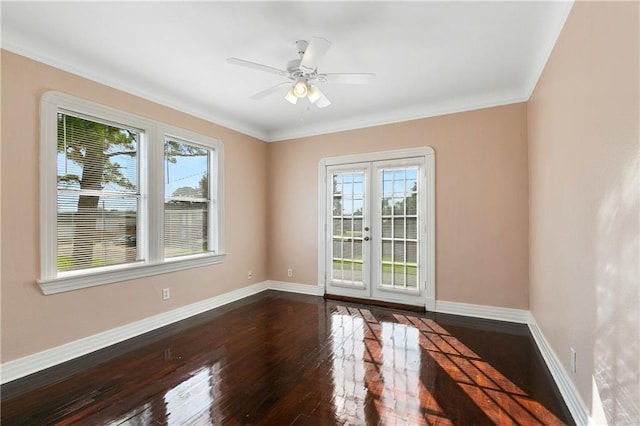 spare room with dark hardwood / wood-style flooring, a wealth of natural light, crown molding, and ceiling fan