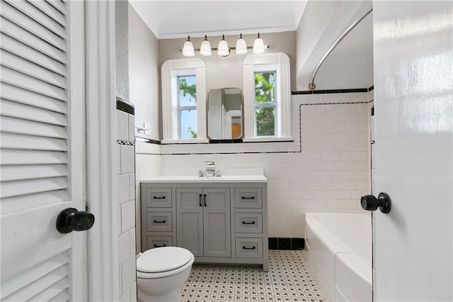 bathroom featuring crown molding, vanity, tile walls, and toilet