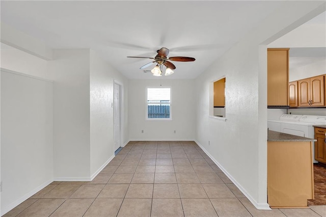 tiled empty room featuring ceiling fan and separate washer and dryer