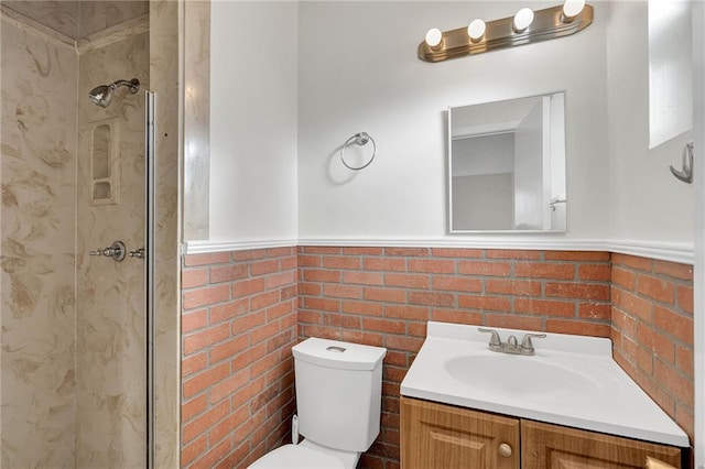 bathroom with vanity, toilet, walk in shower, and brick wall