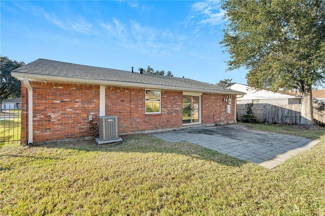 rear view of property featuring a lawn, cooling unit, and a patio