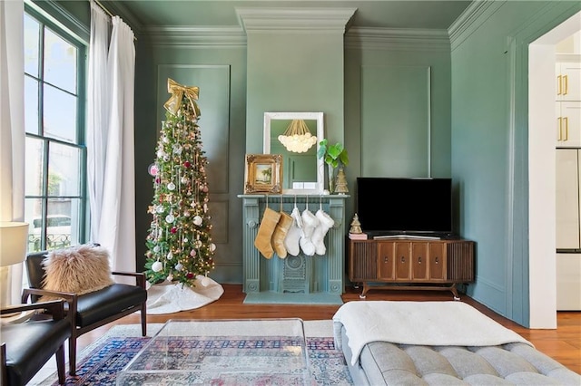 sitting room featuring crown molding, a healthy amount of sunlight, and hardwood / wood-style flooring