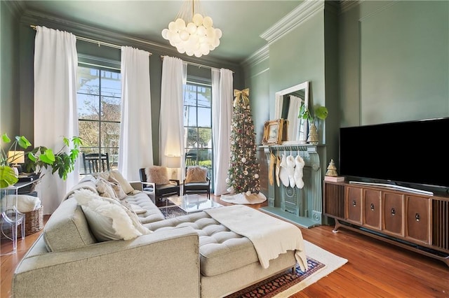 living room featuring wood-type flooring, crown molding, and a chandelier